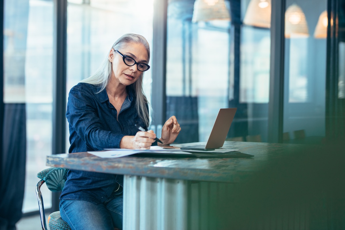 senior woman sitting at table in office and