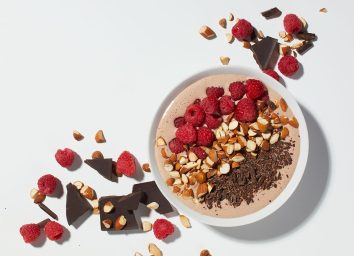 mexican chocolate smoothie bowl with raspberries and chopped chocolate
