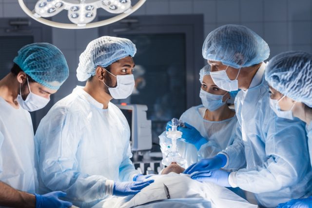 Surgical team preparing their patient for surgery adjusting oxygen mask on face at the operating theatre