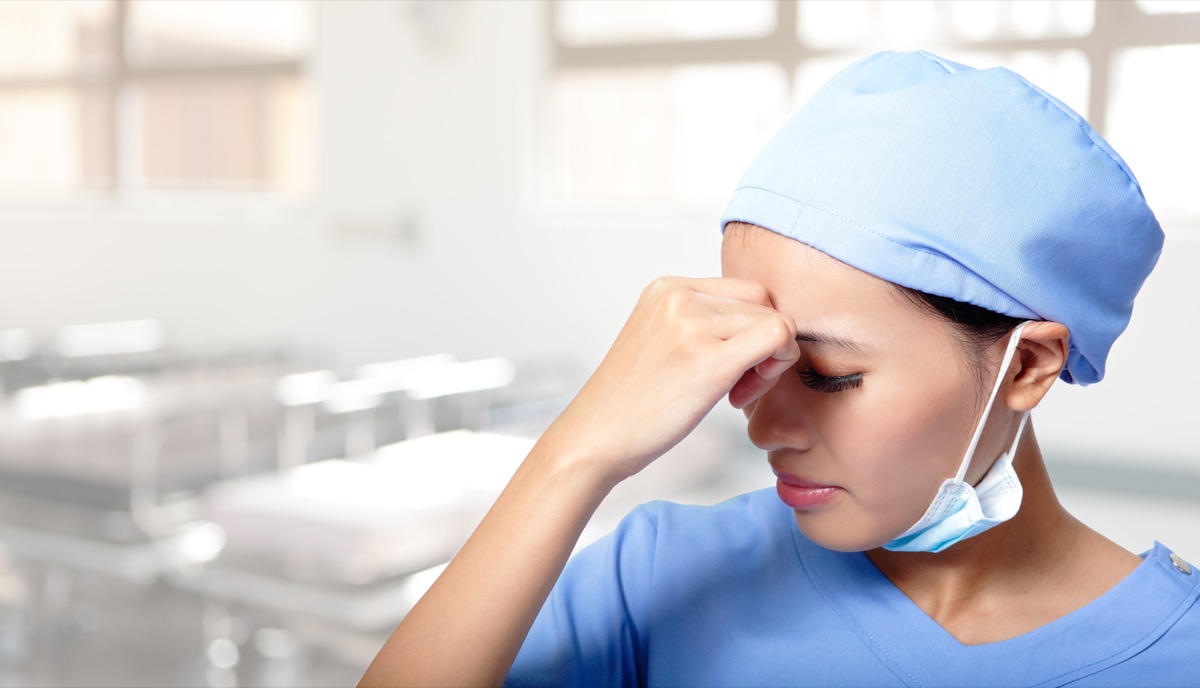unhappy upset woman medical doctor or nurse sad and depressed having stress breakdown in hospital