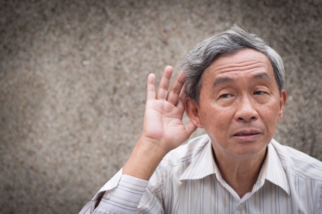 sad senior listening, old man hearing concept of deafness or hard of hearing