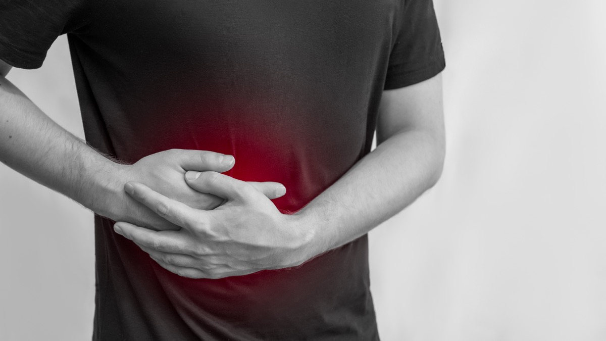  man holds the liver. Pain in the abdomen. Cirrhosis of the liver. Sore point highlighted in red