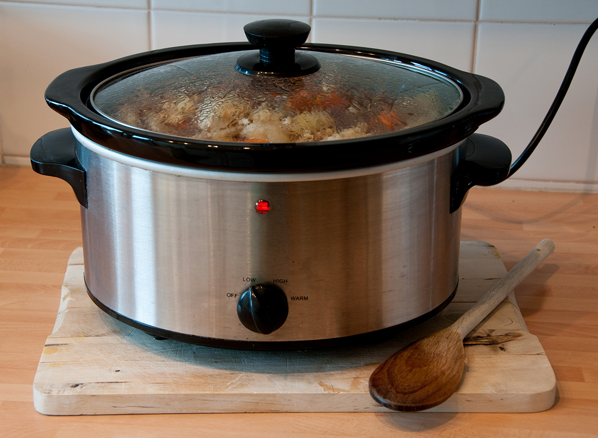 ingredients in slow cooker with wooden spoon