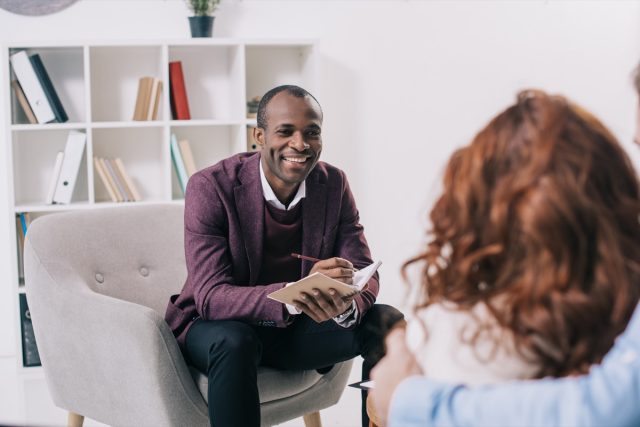 african american psychiatrist talking to young couple