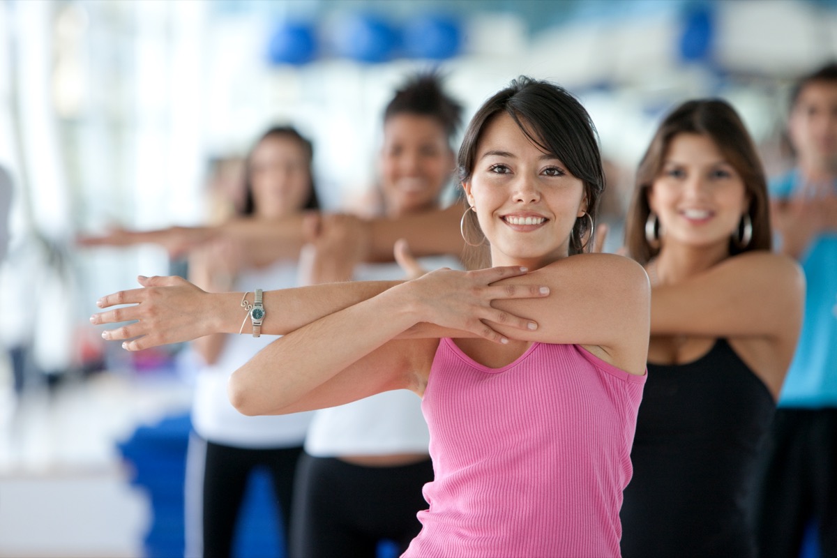 group of gym people in a stretching class