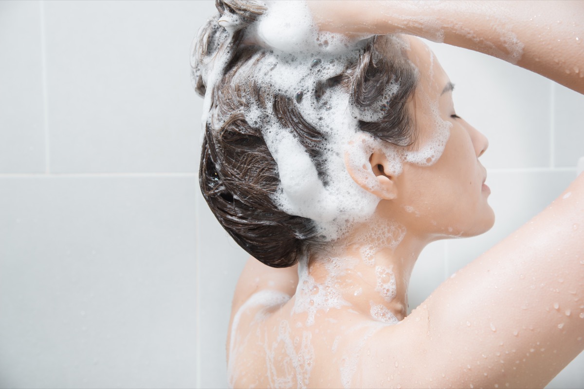 rubbing herself with a washing cloth in the shower and lot of foam