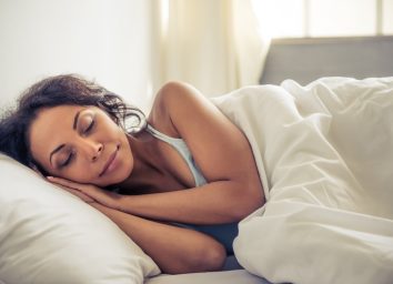 woman smiling while sleeping in her bed at home