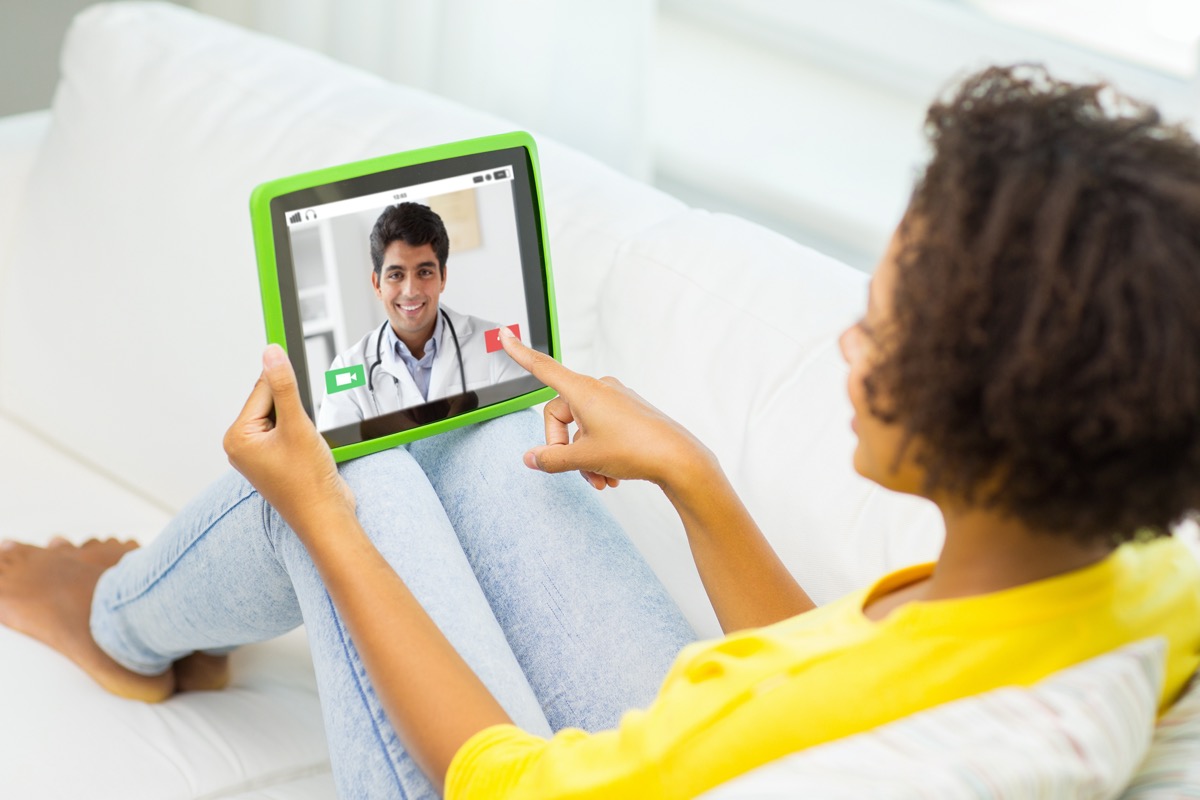 woman or patient having video chat with doctor on tablet pc computer at home