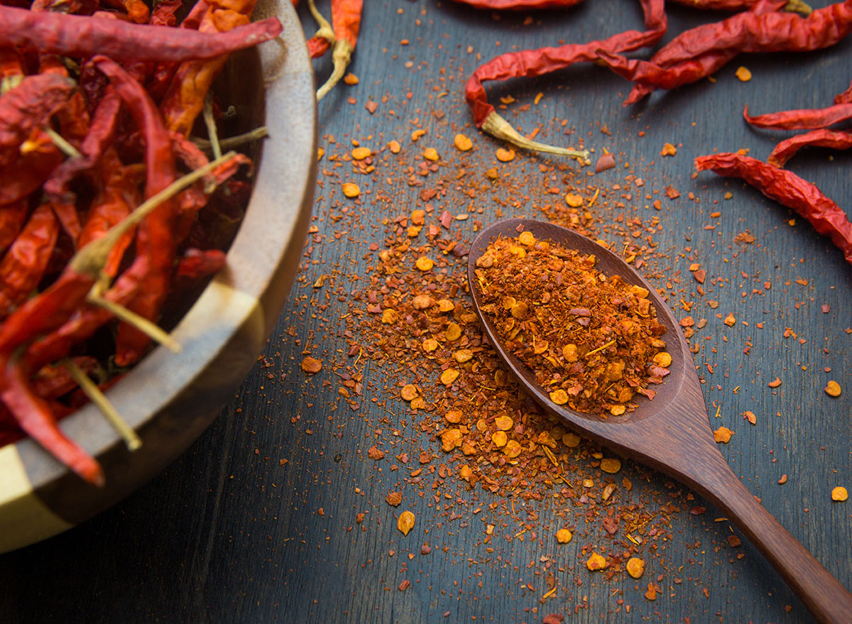 cayenne pepper on wooden spoon and table
