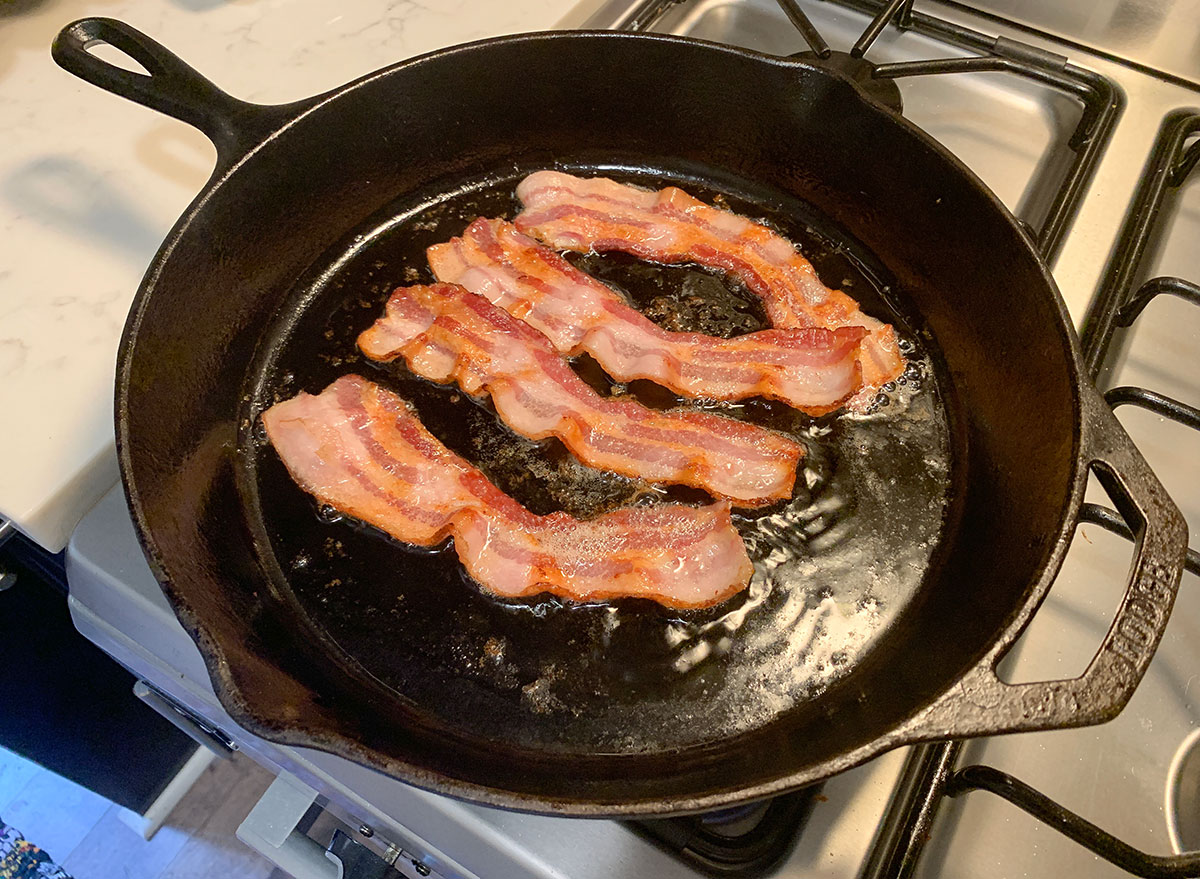 bacon on the stovetop in a cast iron skillet