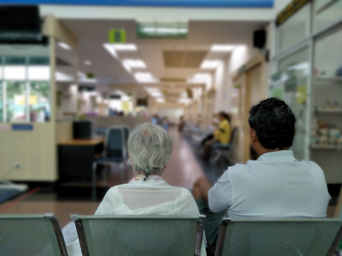 old woman and adult man sit on gray stainless chair waiting medical and health services to the hospital,patients waiting treatment