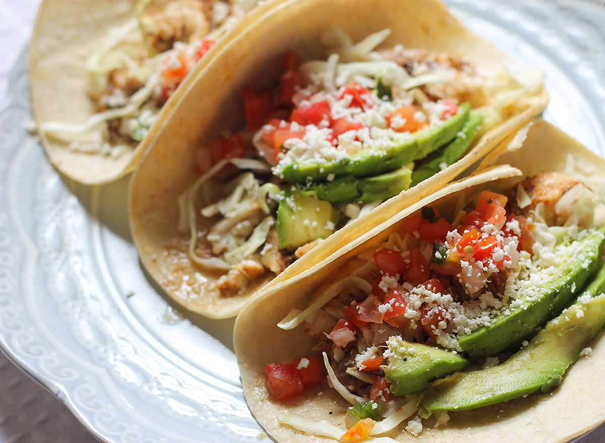 fish tacos on a plate with avocado