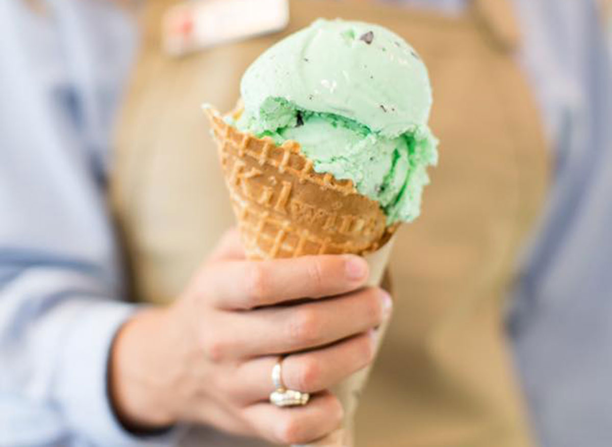 woman holding kilwins mint chocolate chip ice cream in waffle cone