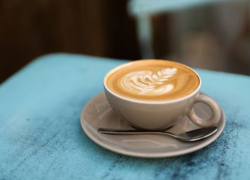 light brown hot fresh mocha on light blue table