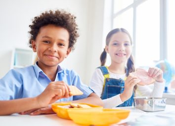 little boy and girl eating snack at school, peanut free preschool snacks