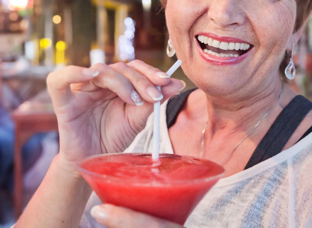 Older woman drinking frozen margarita