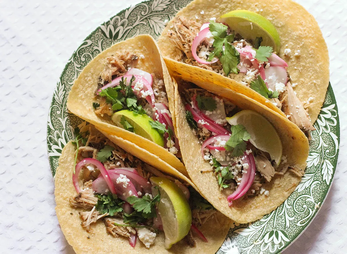 Four pork carnitas tacos on a plate