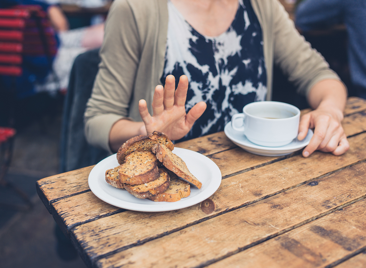 woman refrains from touching a plate of bread