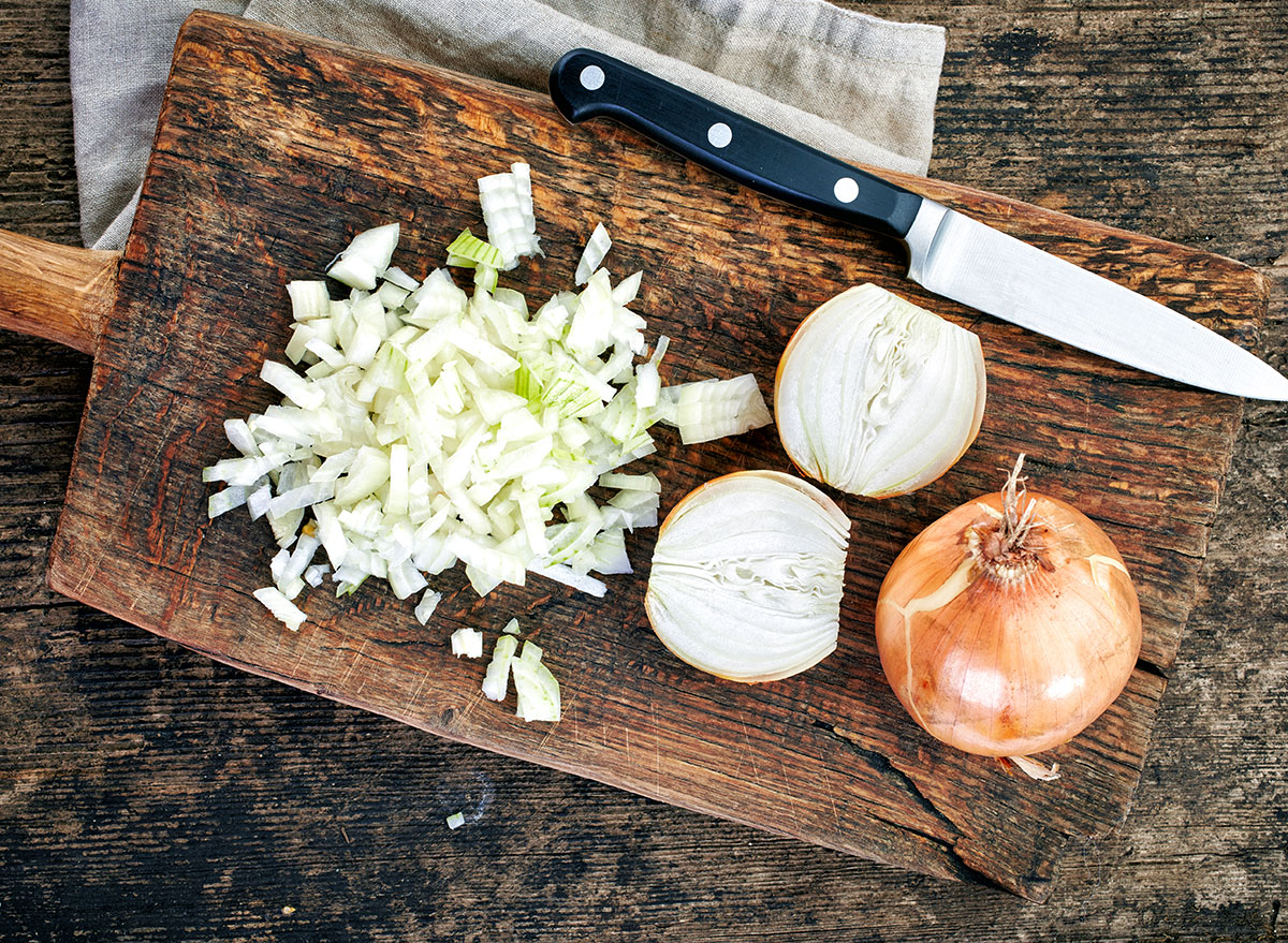 sliced chopped onions on cutting board with knife