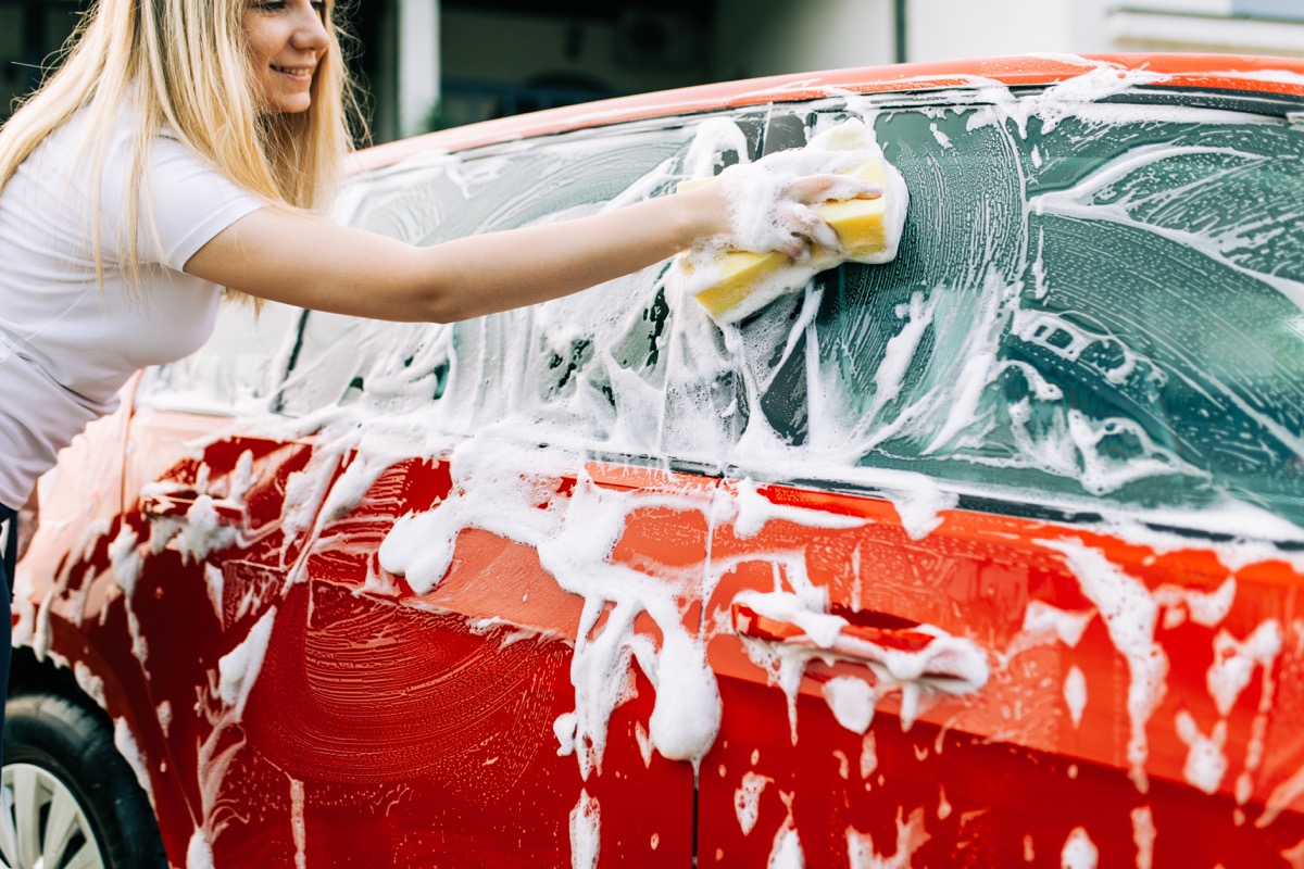 woman washing her car with sponge