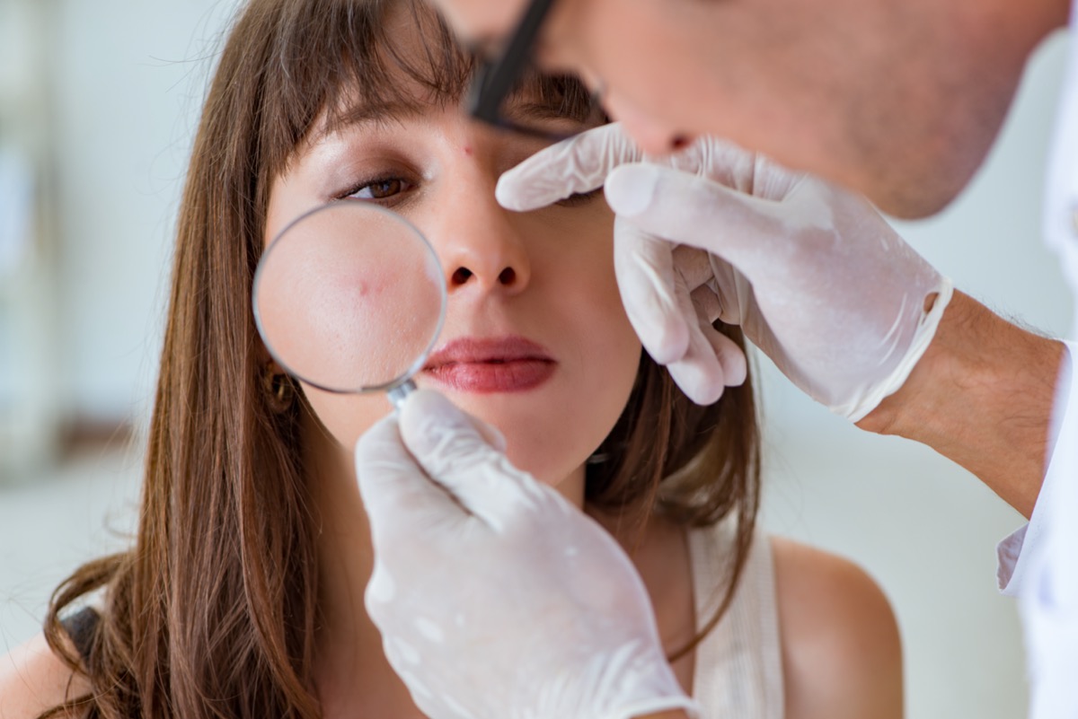 Woman pimple doctor dermatologist magnifying glass