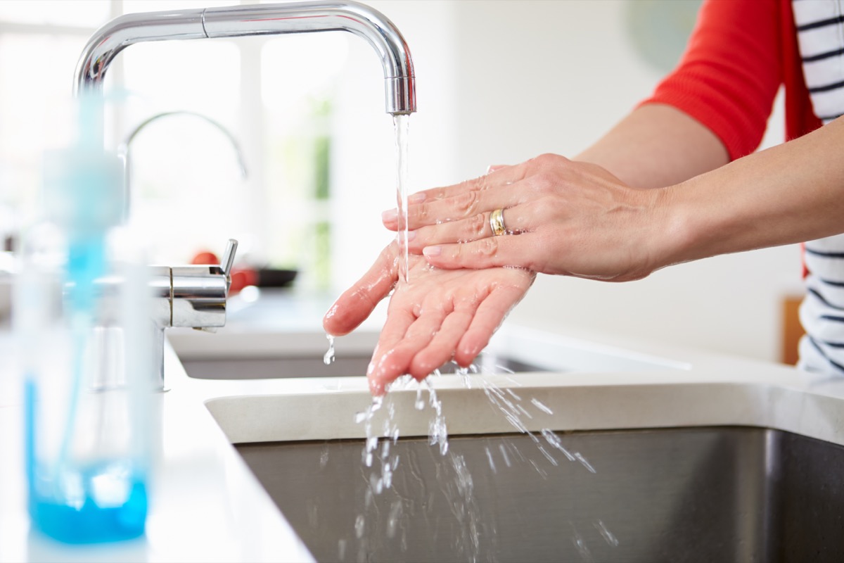 Woman Washing Hands In Kitchen Sink