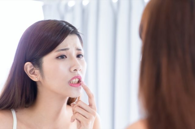 woman worry about her teeth and look in the mirror.