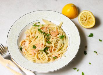 Garlic shrimp scampi recipe with linguine on a marble counter with squeezed lemon
