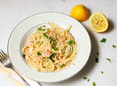 Garlic shrimp scampi recipe with linguine on a marble counter with squeezed lemon