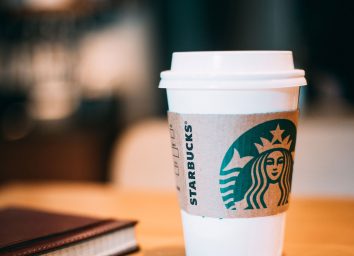 Starbucks cup of coffee at a table with a notepad