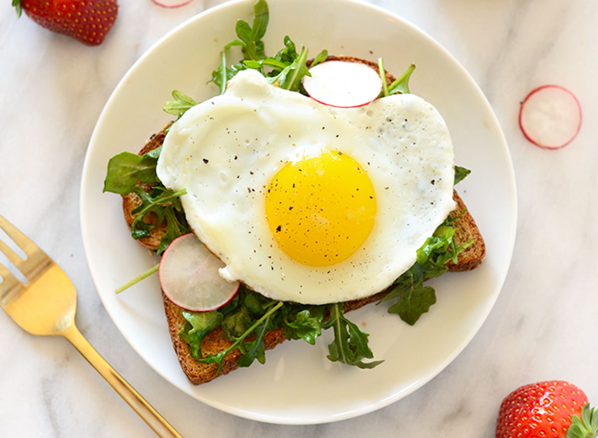 Open face breakfast toast with egg and arugula