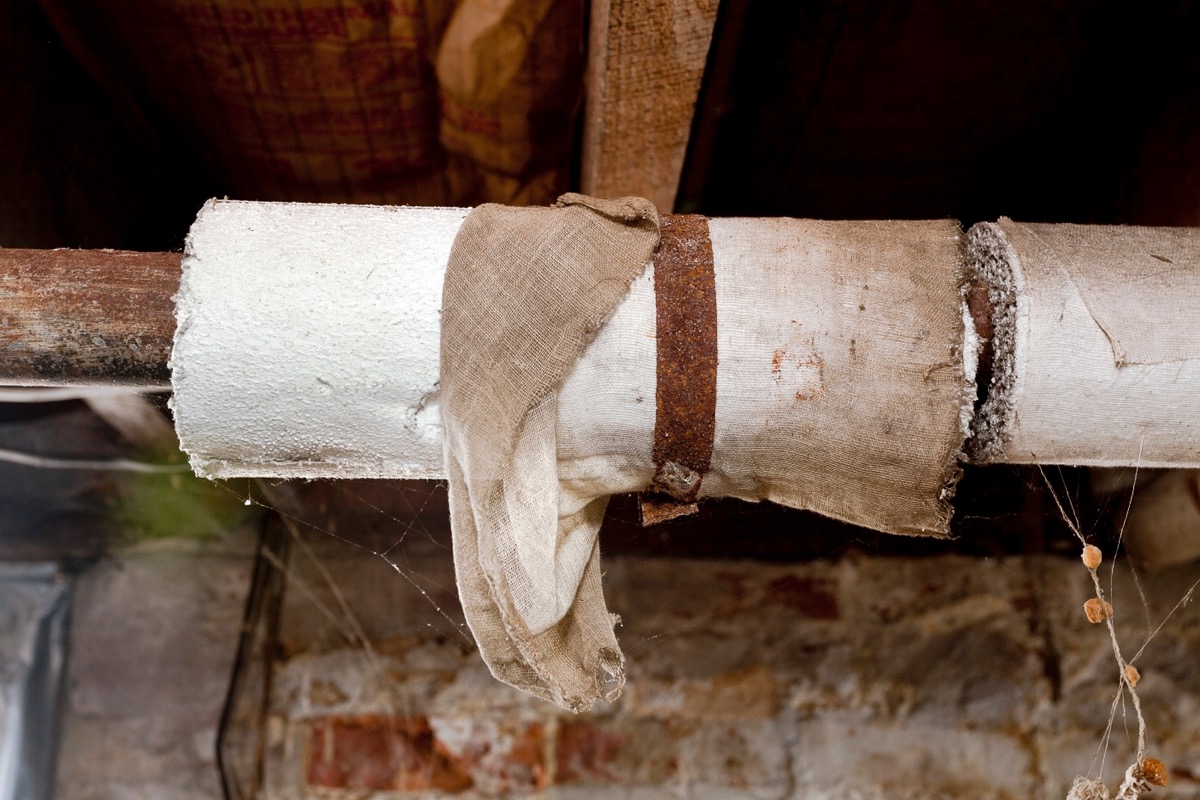 Basement plumbing pipes wrapped with asbestos insulation