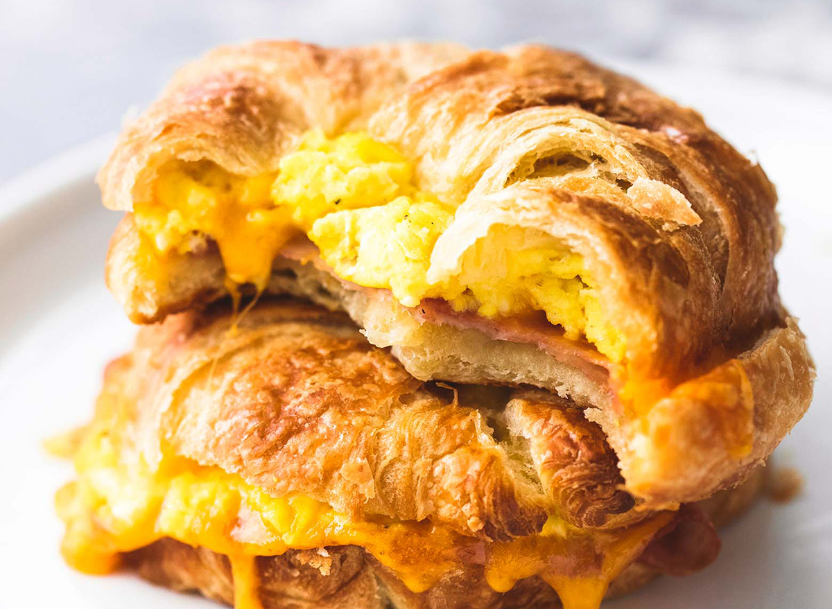 Croissant breakfast sandwich with eggs, cheese, and ham.