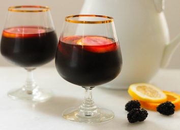 Copycat Carrabbas Blackberry Sangria in two glasses with a pitcher