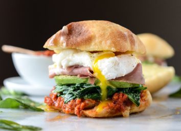 Breakfast sandwich with egg, ham, avocado on a ciabatta roll.