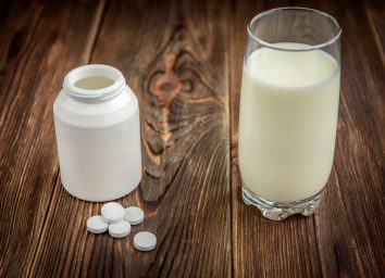 Calcium supplement tablet pills on dark wooden background