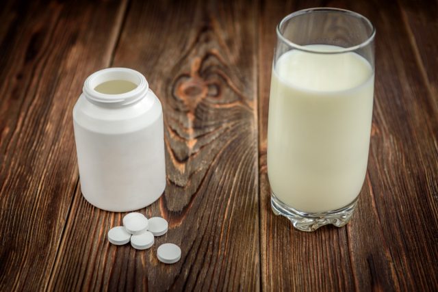 Calcium supplement tablets on dark wooden background