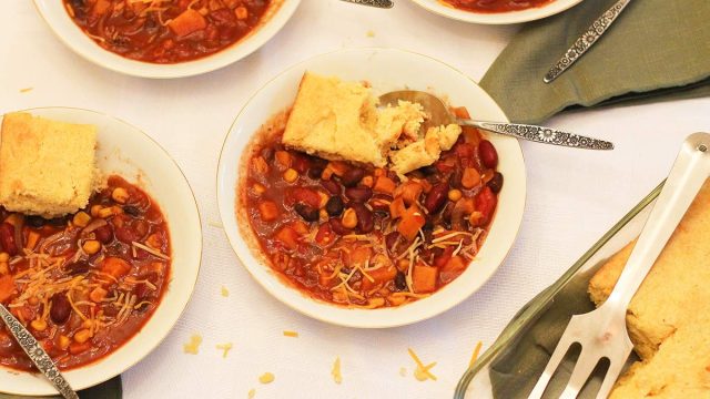Crock pot vegetarian chili recipe with cheese and cornbread for the table