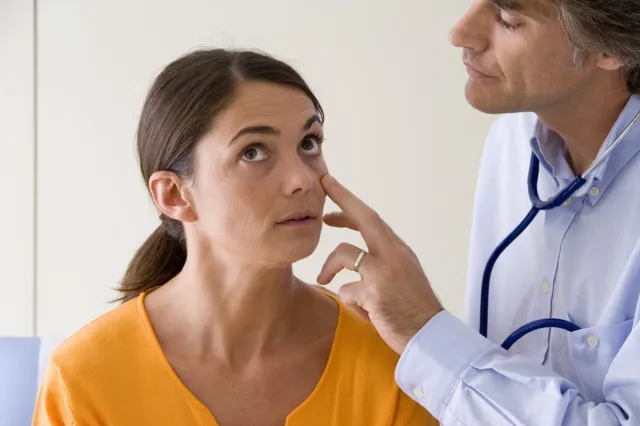 Doctor checking patient for symptoms of anemia