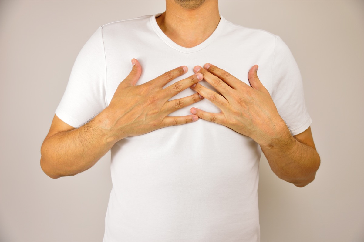 man with both hands on breast