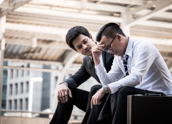 Frustrated Asian young business man sitting outdoor office