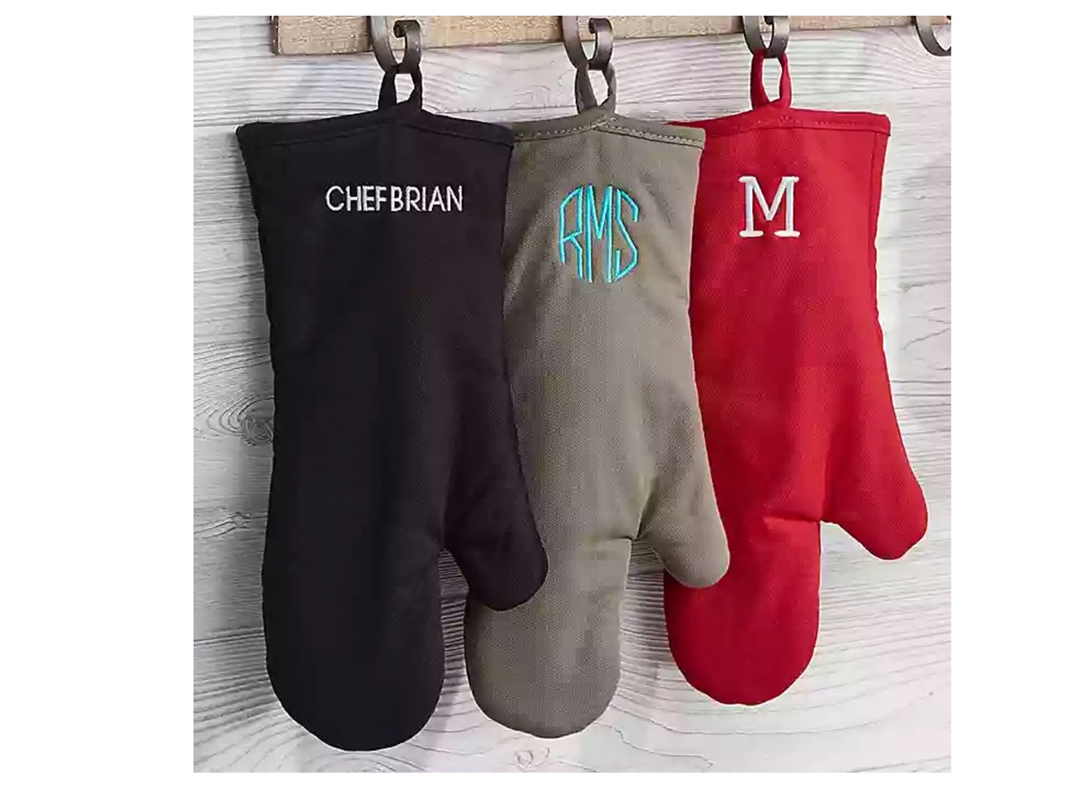 three oven mitts hanging from a metal rack, monogrammed kitchen accessories