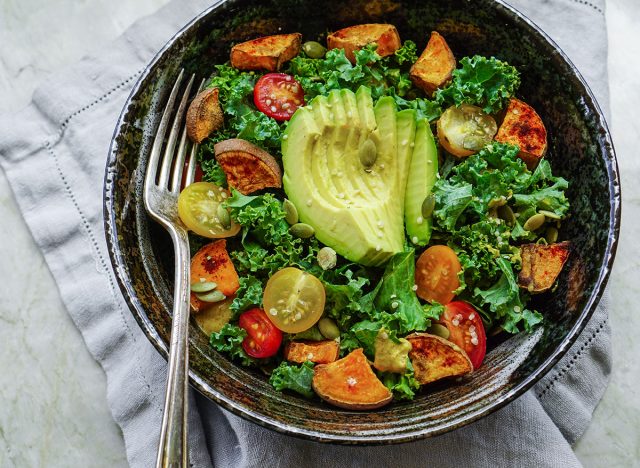 Bowl of paleo diet foods with kale, avocado, tomatoes, and potatoes