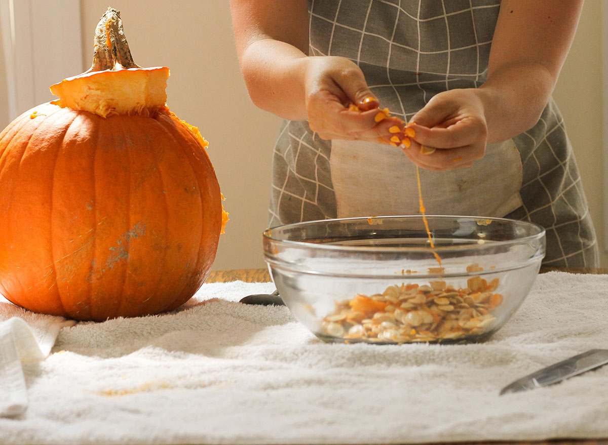 Seperating pumpkin from pumpkin seeds in a bowl