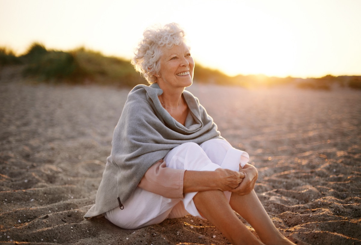 Senior caucasian woman sitting on the beach outdoors