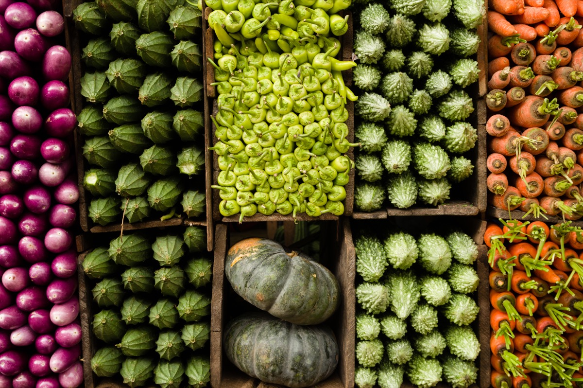 Several varieties of tropical vegetables neatly arranged for sale