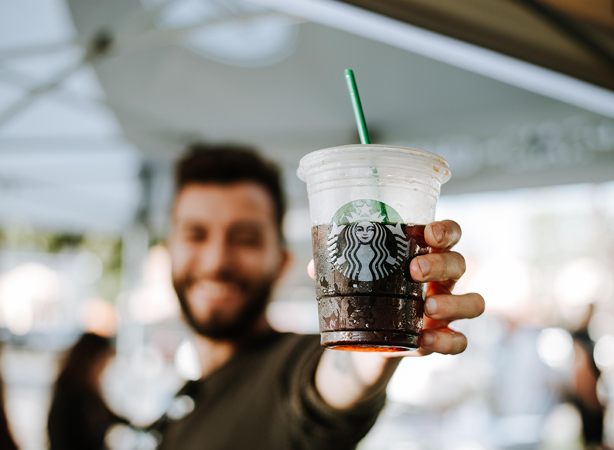 Starbucks customer holding an iced coffee in the summer time