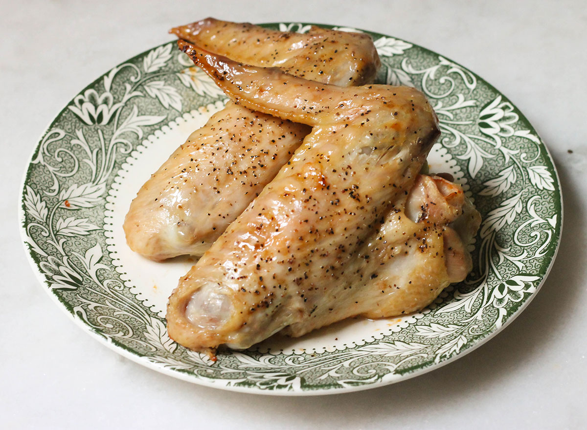 Two baked turkey wings on a plate ready to eat