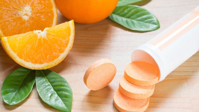 Vitamin c effervescent tablet spilling out of white plastic bottle