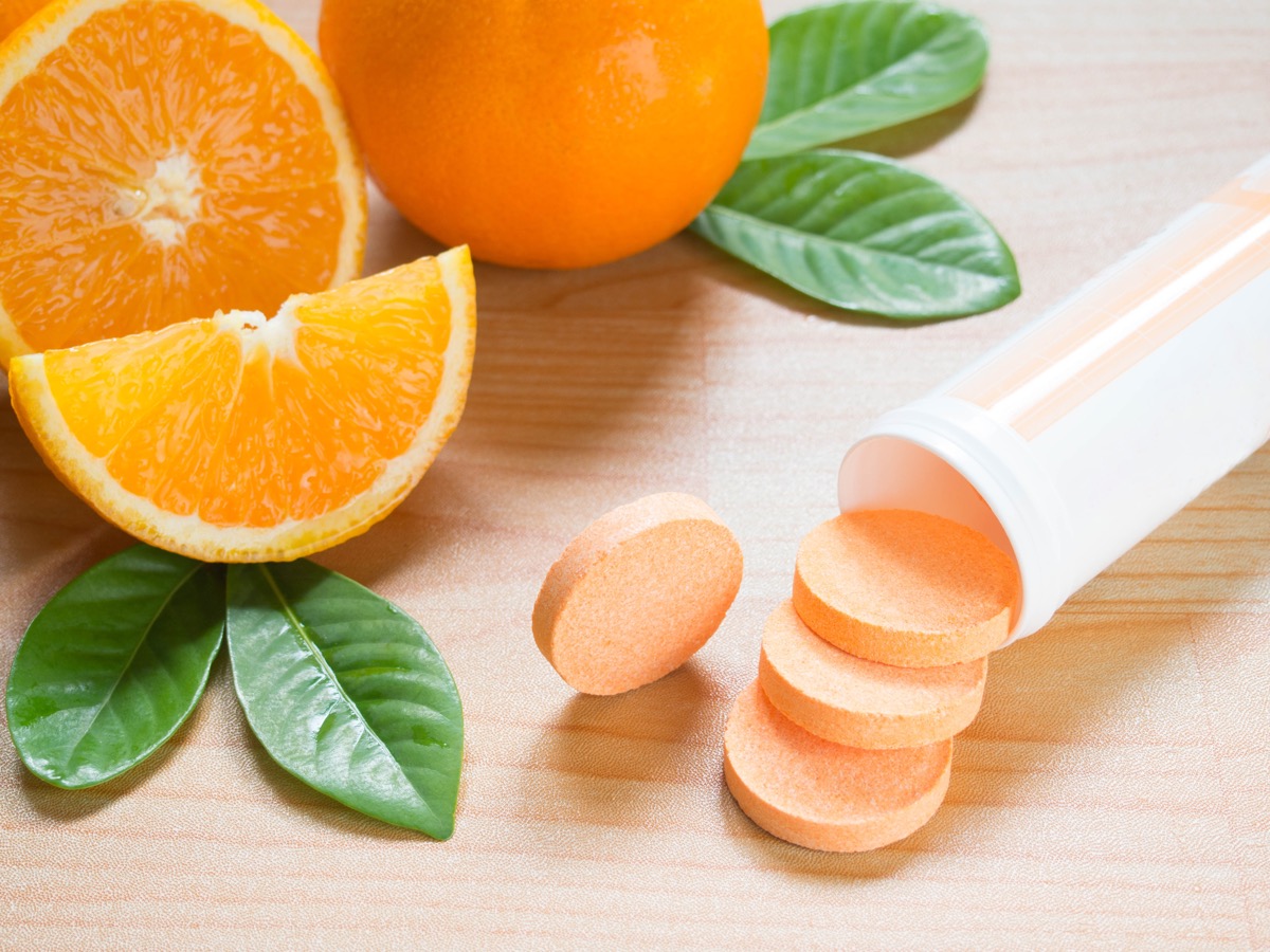 Vitamin c effervescent tablet spilling out of white plastic bottle